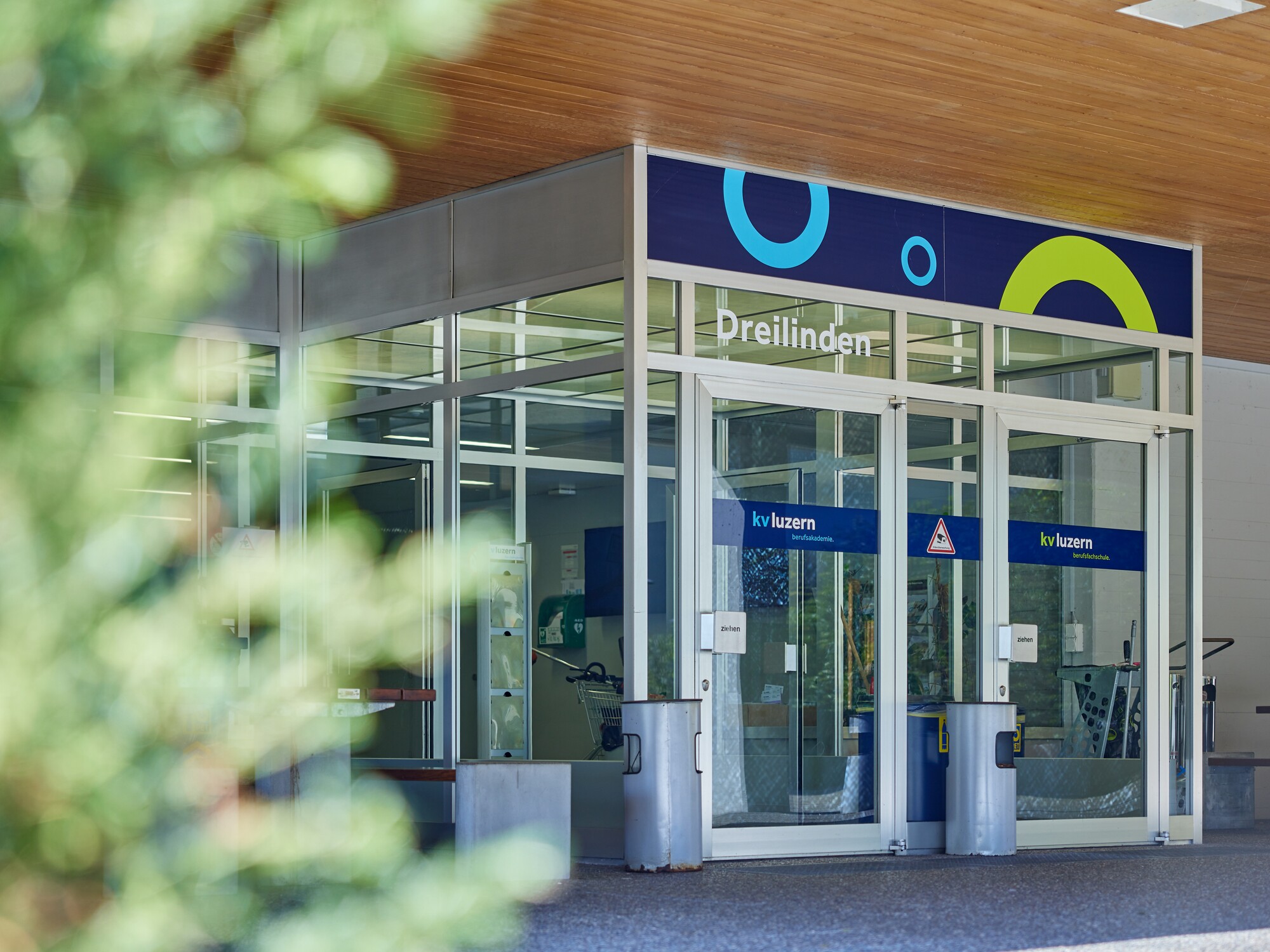 Eingang Schulzentrum Dreilinden / Propsteimatte Eine grosse helle Glastür bildet den Eingang zum Schulzentrum Dreilinden der KV Luzern Berufsakademie.